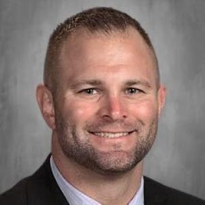 A person in a suit smiling