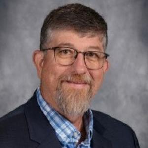 A person wearing glasses and a suit