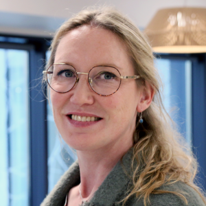 Light haired person with glasses smiling