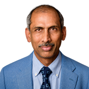 Person in blue suit and shaved hair looking at the camera