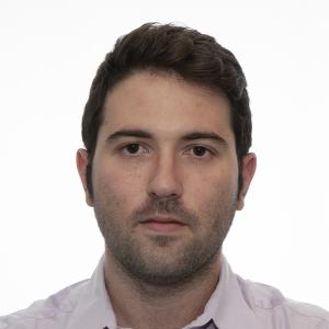 Person with white shirt in front of a white background looking at the camera