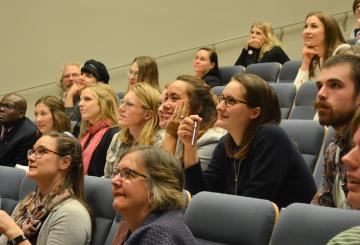 Interested looking audience members smiling and looking at the presenter