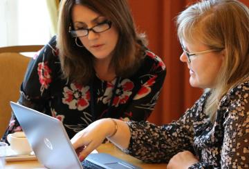 Mercer University and University of Turku representatives discussing and looking at a laptop during the IAPP delegation visit to Finland